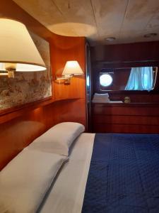 a bedroom with a bed and a window on a boat at Yatch Nelly Blue Rome in Lido di Ostia