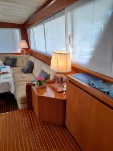 a living room with a couch and a table with a lamp at Yatch Nelly Blue Rome in Lido di Ostia