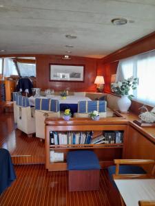 a boat with a table and chairs in a room at Yatch Nelly Blue Rome in Lido di Ostia