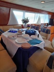 una mesa en un barco con platos y platos. en Yatch Nelly Blue Rome, en Lido di Ostia