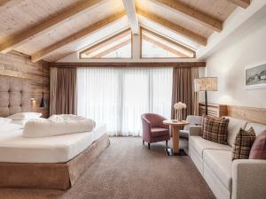 a hotel room with a bed and a couch at Hotel Magdalena Mayrhofen in Mayrhofen