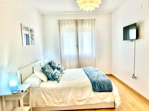a bedroom with a bed with blue pillows on it at Apartamento Mirando al Guadiana Centro in Ayamonte