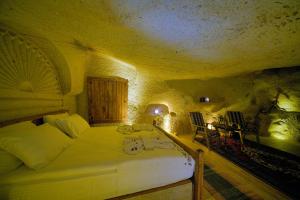 A bed or beds in a room at Babili Cappadocia Cave