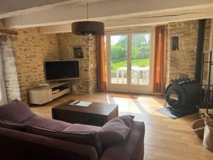 sala de estar con sofá y TV en sejour paisible au coeur du morbihan, en Pluvigner