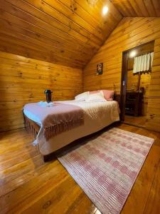1 dormitorio con 1 cama en una cabaña de madera en Glamping El Reencuentro, en Machachi
