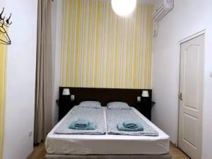 布達佩斯的住宿－A4 Parliament Sunflower Cozy Apartment，一间卧室配有一张床,上面有两条毛巾