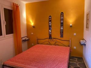 Un dormitorio con una cama roja en una habitación amarilla en Granatapfel en Porto Heli
