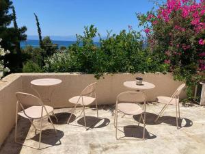 un grupo de mesas y sillas sentadas en un patio en Granatapfel en Porto Heli