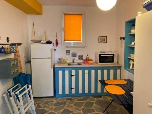 a kitchen with a blue and white refrigerator and a table at Granatapfel in Porto Heli