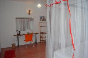 Zimmer mit einem Bett, einem Tisch und einem Vorhang in der Unterkunft FEEL Beach Villa in Kalutara