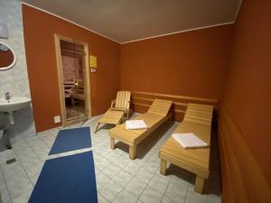 a room with two benches and a sink and a bathroom at Hotel Prichovice in Kořenov