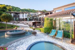 a backyard with a pool and two chairs and a house at Villa Helia in Dolný Kubín