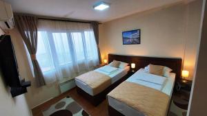 una camera d'albergo con due letti e una finestra di Hotel Villa Panorama a Belgrado