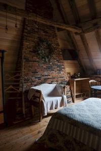 1 Schlafzimmer mit Ziegelwand und 2 Betten in der Unterkunft Les Jardins de la Contie in Lunan