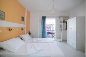 1 dormitorio con 2 camas blancas y cocina en Studios Stratos en Naxos