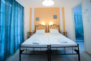 a bedroom with a large bed with blue curtains at Studios Stratos in Naxos Chora