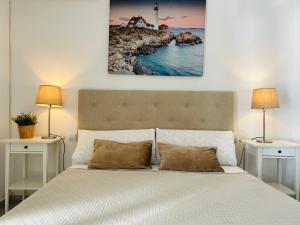 a bedroom with a bed with two lamps and a lighthouse at Malagueta Beach Premium in Málaga