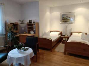 uma sala de estar com duas camas e uma mesa em Apartment HAUS MERLIN am Böckelsberg em Weimar