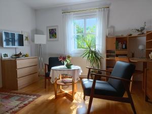 Apartment HAUS MERLIN am Böckelsberg في فايمار: غرفة معيشة مع طاولة وكراسي ونافذة