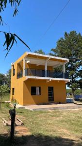duży żółty dom pośrodku pola w obiekcie Casa Birnbaum Ruiz Diaz w mieście Carapeguá