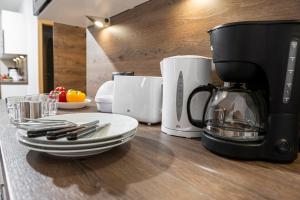 a counter with a coffee maker and plates on it at Hotel Alpendorf Ski- & Sonnenresort by AlpenTravel in Sankt Johann im Pongau