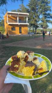 uma pessoa segurando um prato com um pedaço de bolo em Casa Birnbaum Ruiz Diaz em Carapeguá