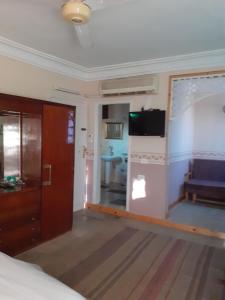 een kamer met een bed, een televisie en een bank bij Villa Nile House Luxor in Luxor