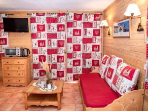 a living room with a couch and a wall of photos at Studio 4 Pers. avec Balcon, Résidence Les Chalets de Praroustan, Pra Loup 1500 - FR-1-504-367 in Uvernet-Fours