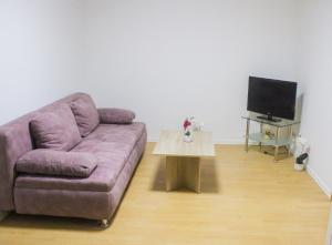 sala de estar con sofá púrpura y mesa en Ferienhaus Seilerbahn 17, en Vallendar