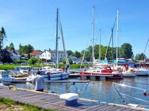 a man standing on a dock with boats in a marina at Ferienwohnung im roten Haus in Stahlbrode