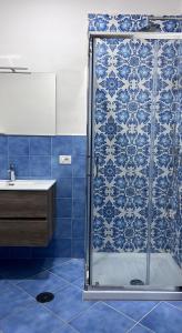 baño azul con ducha y lavamanos en Villa Somma Apartments, en Pimonte