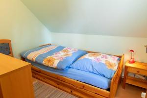 ein Schlafzimmer mit einem Bett mit blauer Bettwäsche und Blumen in der Unterkunft Ferienwohnung Seestraße in Lubmin