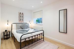 um quarto com uma cama e um espelho em The Pinkish House - 4 bed home in the town centre em Blairgowrie