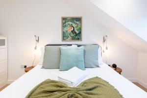 a bedroom with a bed with white sheets and blue pillows at The Pinkish House - 4 bed home in the town centre in Blairgowrie