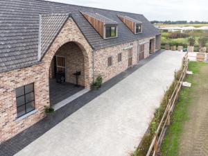 una vista dall'alto di un edificio in mattoni con un vialetto d'accesso di Logies Op 't Gestel a Opglabbeek