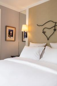 a large white bed with a heart on the wall at La Villa Madame in Paris