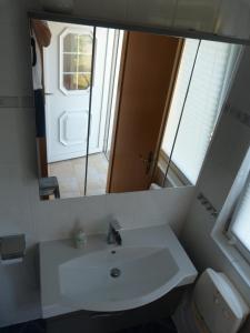 ein Badezimmer mit einem weißen Waschbecken und einem Spiegel in der Unterkunft Bungalow Mandy in Zinnowitz