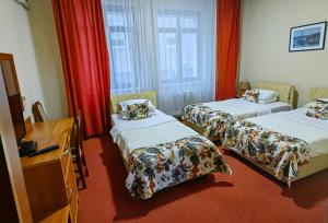una camera d'albergo con due letti e una televisione di Hotel N a Belgrado