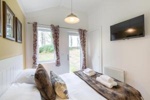 a bedroom with a bed and a window at Squirrel Lodge 43 with Hot Tub in Newton Stewart +12 photos