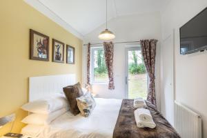 a bedroom with a bed and a window at Squirrel Lodge 43 with Hot Tub in Newton Stewart