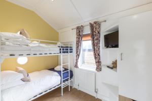 2 łóżka piętrowe w niewielkim pokoju z oknem w obiekcie Squirrel Lodge 43 with Hot Tub w mieście Newton Stewart