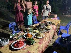 a little girl standing at a table with plates of food at Mada Lanta Mai Keaw in Ko Lanta