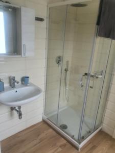 a shower with a glass door next to a sink at G&G Home in Cosenza