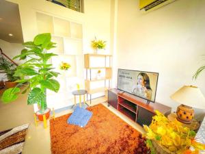 ein Wohnzimmer mit einem Flachbild-TV an der Wand in der Unterkunft Lovely 1BR Loft in BGC Golf View in Manila