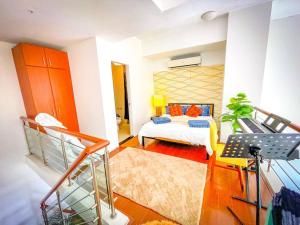 Zimmer mit einem Bett und einer Treppe in der Unterkunft Lovely 1BR Loft in BGC Golf View in Manila