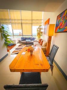 einen Holztisch und Stühle im Wohnzimmer in der Unterkunft Lovely 1BR Loft in BGC Golf View in Manila