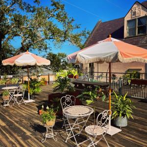 a deck with tables and chairs and umbrellas at Inn at the Old Jail in New Orleans