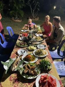 een lange tafel met borden eten erop bij Mada Lanta Mai Keaw in Koh Lanta
