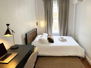 a bedroom with a bed and a desk with a laptop at Outsite Chelsea in New York +12 photos