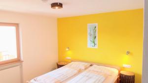 a bedroom with two beds and a yellow wall at Agriturismo Ferienhof Gschloier in Laion